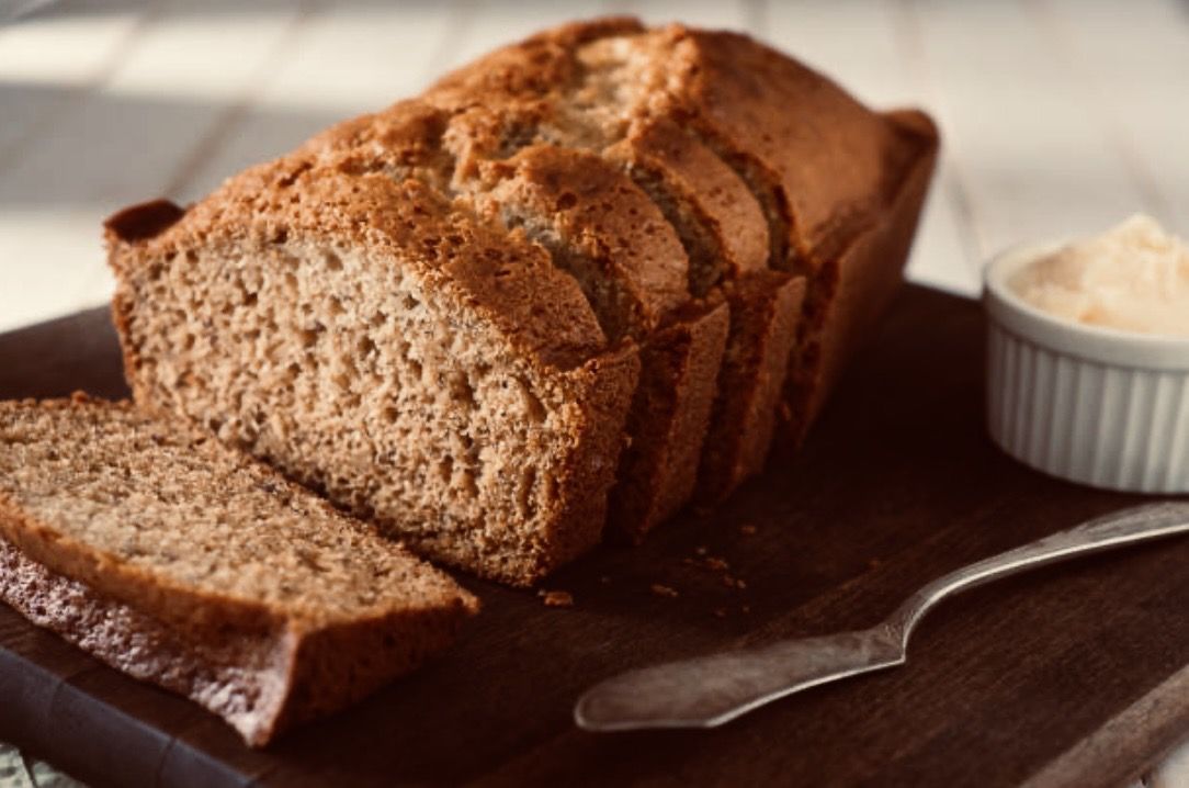 A freshly baked sliced loaf served on a wooden board